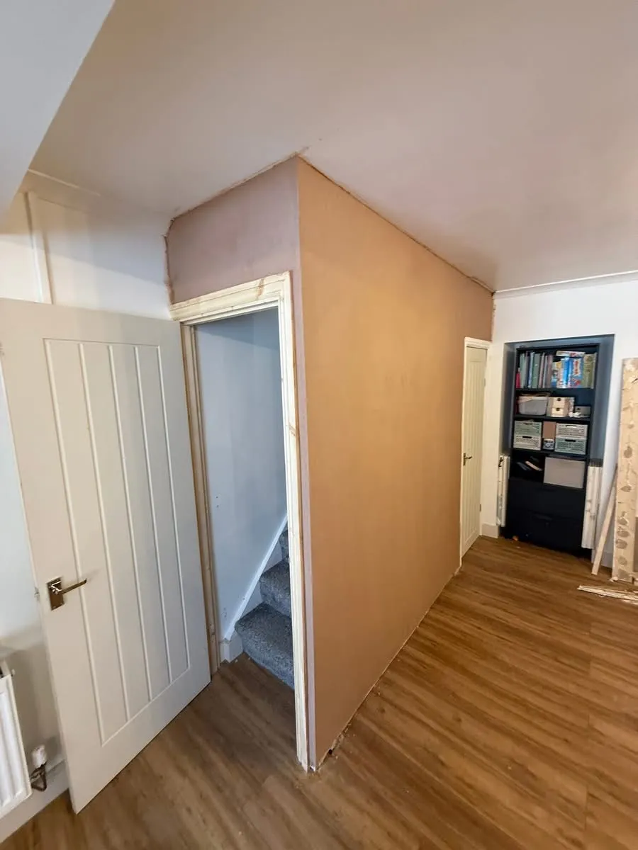 Freshly skimmed wall to a domestic staircase, alongside new wood architrave